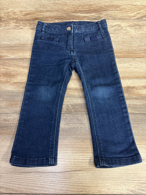 Dark wash toddler jeans with straight legs on wood background, gently used kids clothing