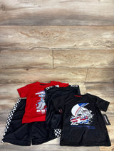 Flat-lay of Members Only 4-piece boys' set (size 5T) showing red and black graphic tees with shark and race designs and black checkered shorts on wood floor