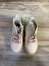 Overhead view of Amaya toddler zipper combat boots in cream and pink showing side zippers and glittery laces on wood floor