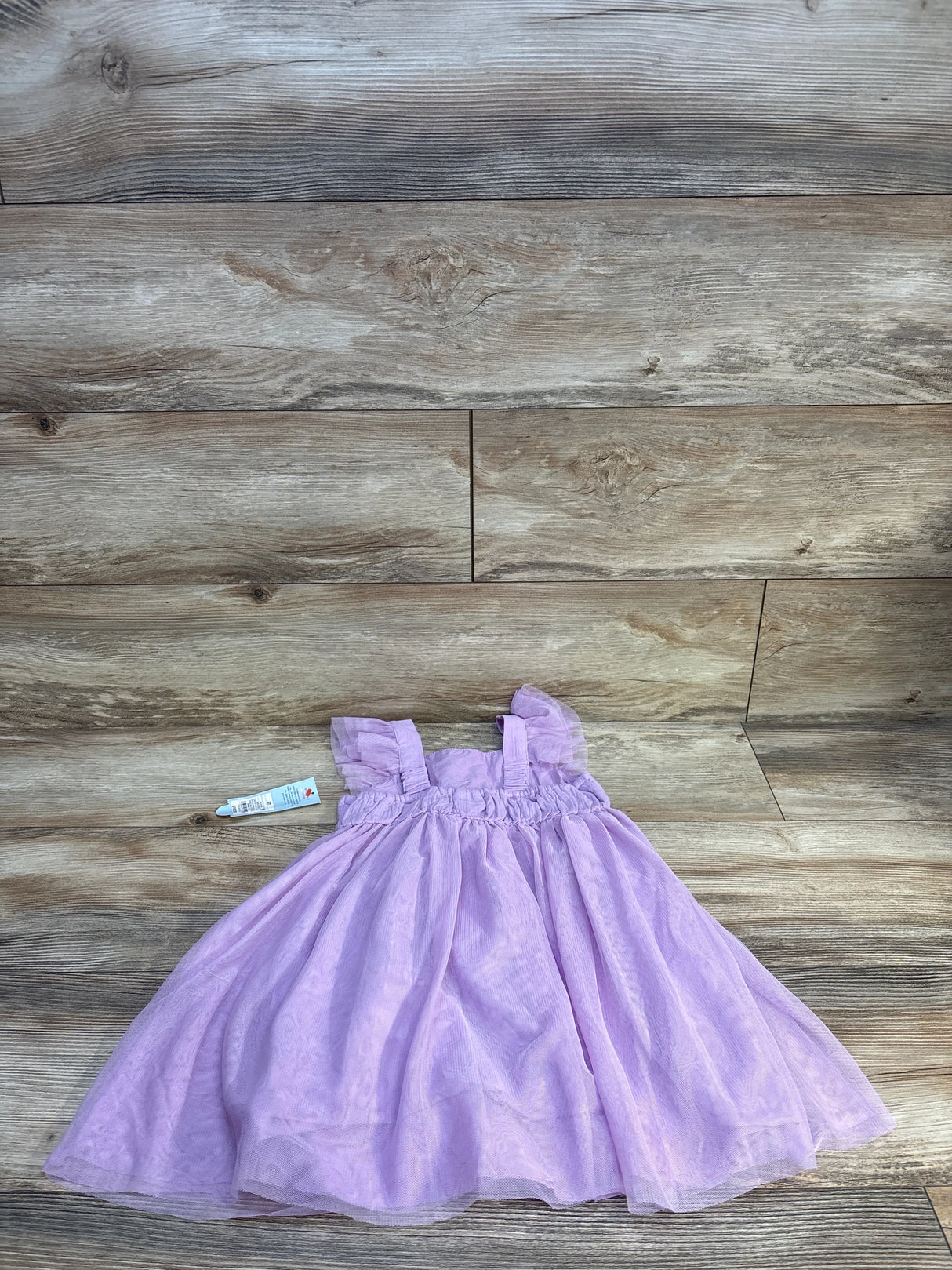 Light purple toddler dress with ruffle sleeves on wood background, kids clothing resale