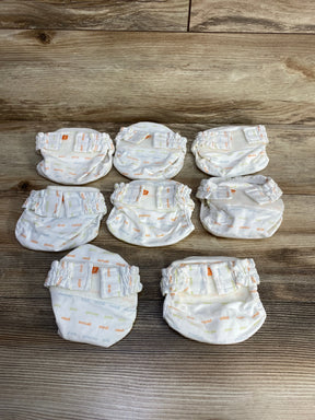 Top-down of eight newborn gDiapers cloth diaper covers, ivory word-print, elastic legs and Velcro tabs on wood