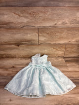 Light blue floral sleeveless girls dress with satin bow on wood background