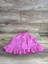 Top-down view of toddler pink floral halter dress (24 months) showing ruffled hem and swirled floral pattern on wood floor
