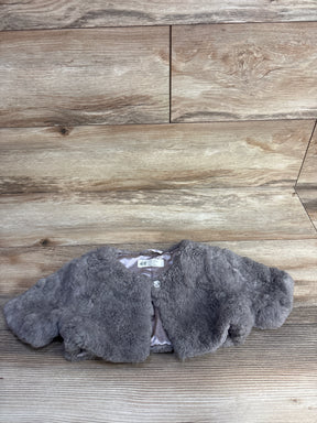 Gray faux fur cropped jacket from H&M laid on wood floor background