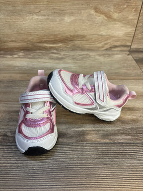 Pink and white toddler sneakers with Velcro straps on wood background