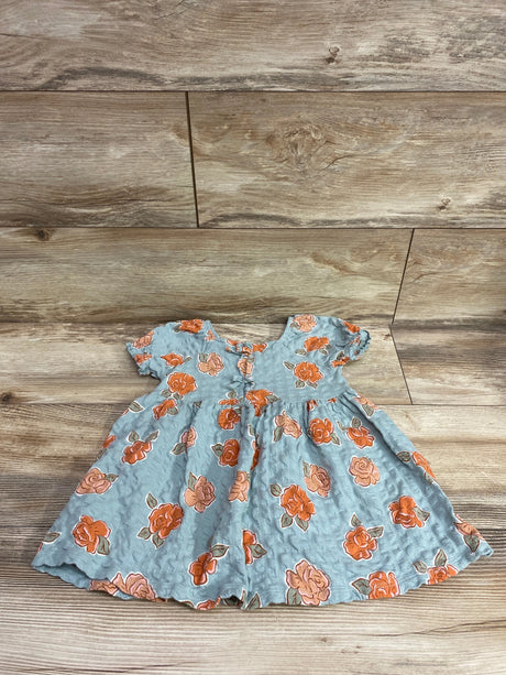 Front view of Little Co. blue floral dress in size 2T showcasing short sleeves and gathered waist on a wood-look background