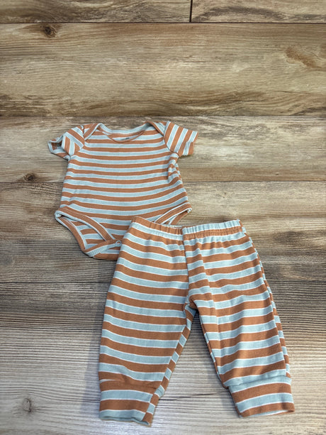 Striped baby bodysuit and pants set with tan and white horizontal stripes on wood background