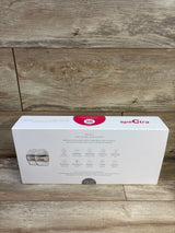 Front view of Spectra Premier wearable electric breast pump box showing product image and feature icons on wood background