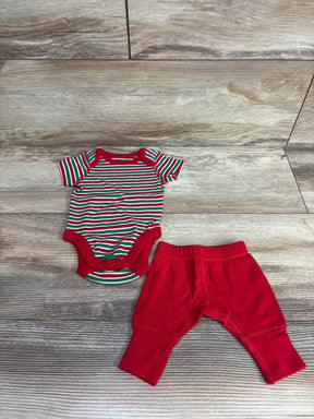 Red and green striped baby onesie with matching red pants, holiday-themed infant outfit on wood floor