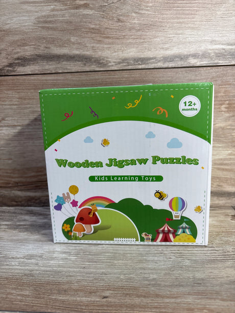 Front view of wooden jigsaw puzzles box showcasing colorful animal illustrations and "12+ months" age label on wooden tabletop