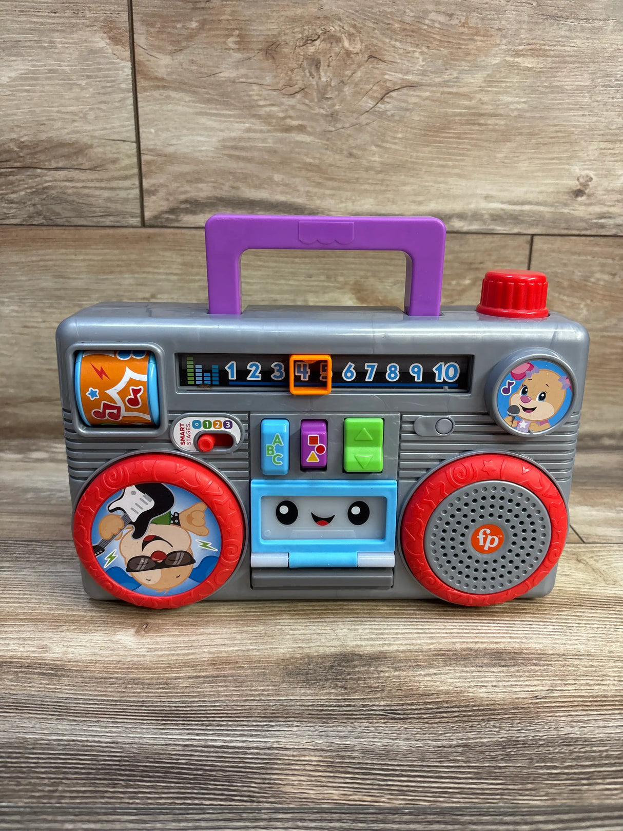 Front view of Fisher Price Laugh & Learn Busy Boombox with colorful buttons, numbered display, and purple handle