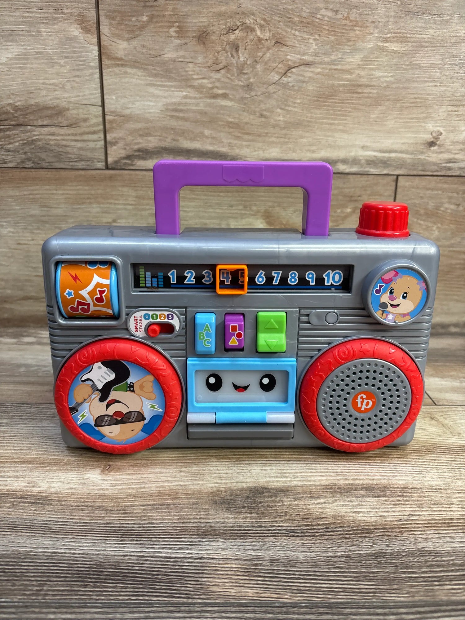 Front view of Fisher Price Laugh & Learn Busy Boombox with colorful buttons, numbered display, and purple handle