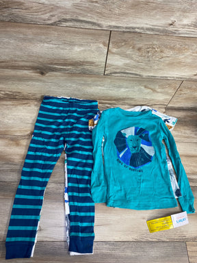Children's blue striped pajama pants and long sleeve shirt with lion graphic and ‘King of Bedtime’ text on wood floor