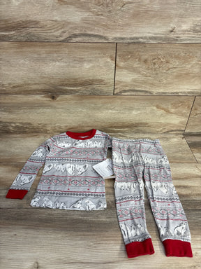 Children's two-piece pajama set with polar bear and snowflake pattern, red cuffs and collar on wood floor