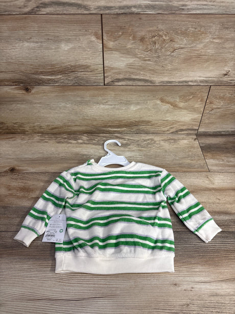 White and green striped children's long sleeve shirt on white hanger on wooden floor