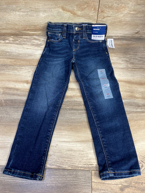 Kids dark wash skinny jeans, size 4T, with tags, laid flat on wood floor