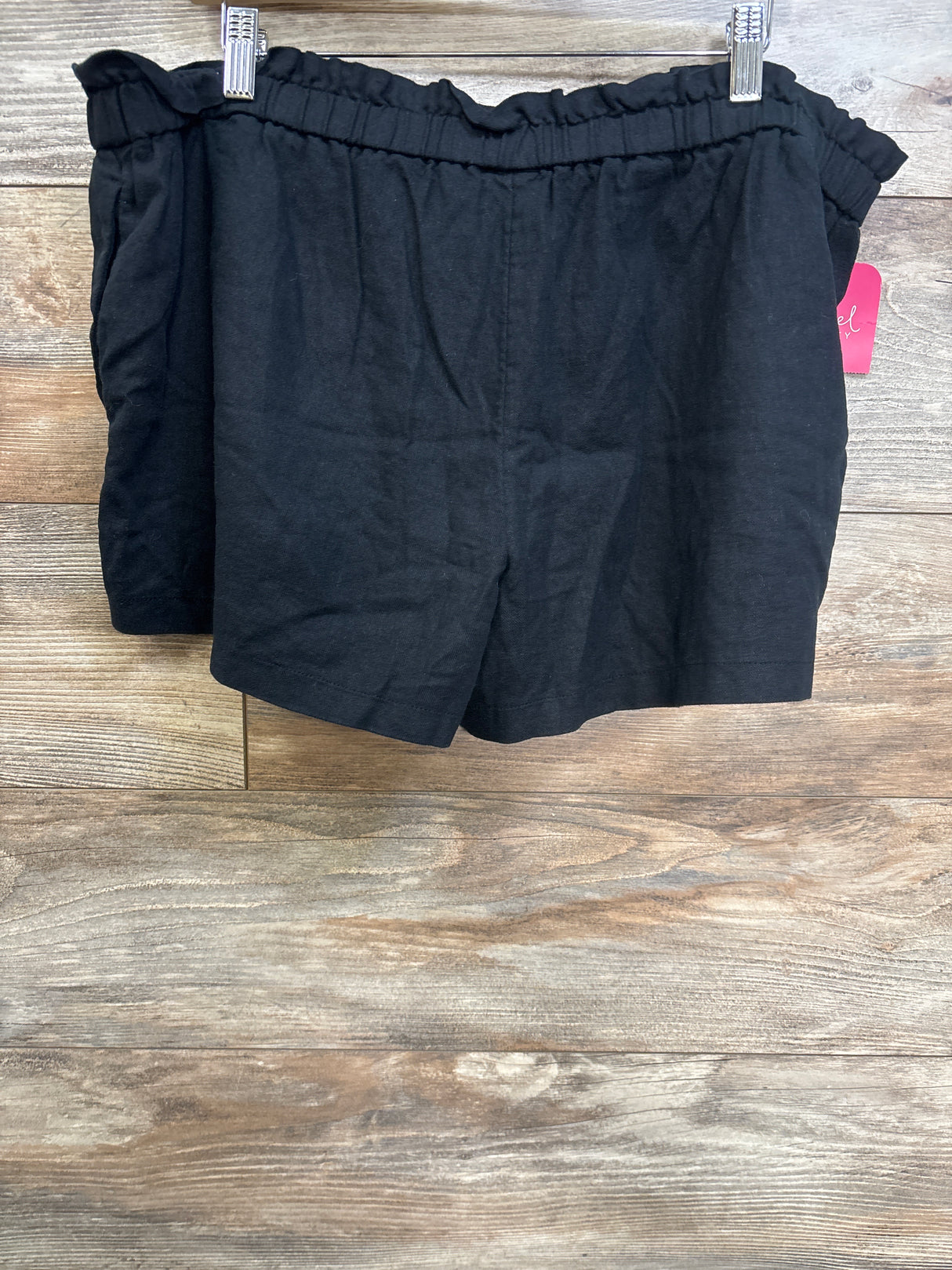 Front view of Isabel maternity black pull-on shorts showing ruffled elastic waist and relaxed fit on wood background