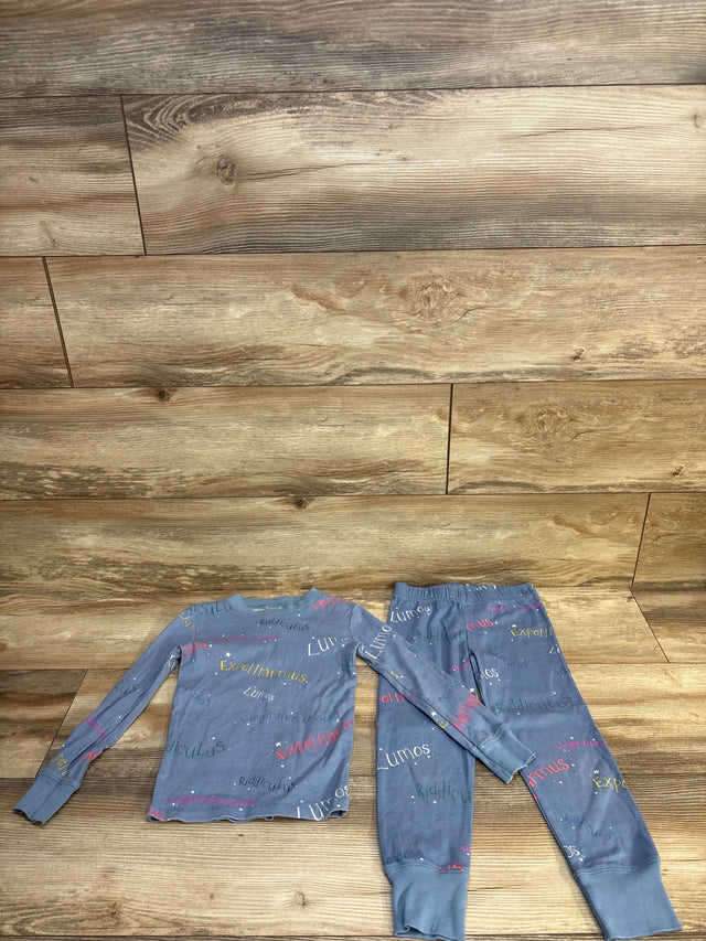 Blue long sleeve kids pajama set with colorful text print, displayed on wood background.