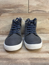 Pair of kids high-top navy sneakers with white soles on wooden floor
