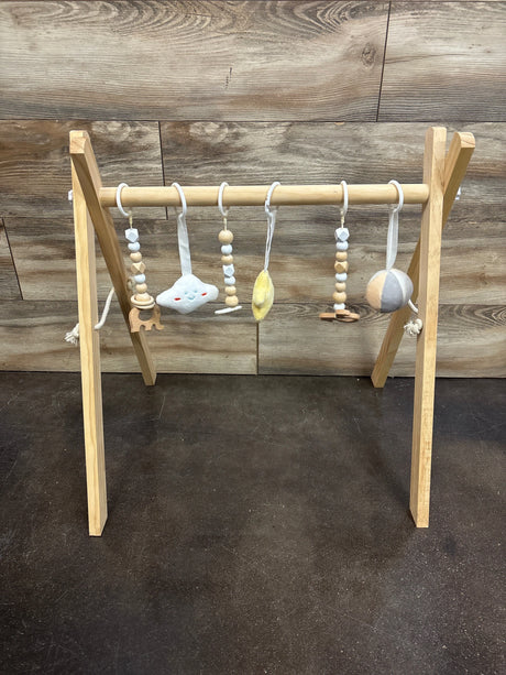 Front view of Mallify wooden baby activity gym showcasing hanging sensory toys with a wood plank background