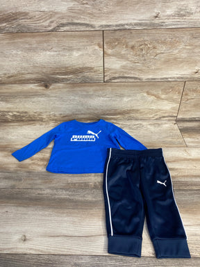 Blue Puma long sleeve shirt and navy Puma track pants on wood floor