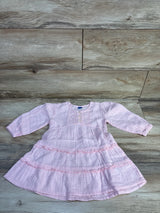 Flat lay of pink Old Navy long-sleeve tiered dress showing ruffled tiers, front buttons, textured fabric on wood background
