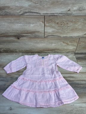 Flat lay of pink Old Navy long-sleeve tiered dress showing ruffled tiers, front buttons, textured fabric on wood background
