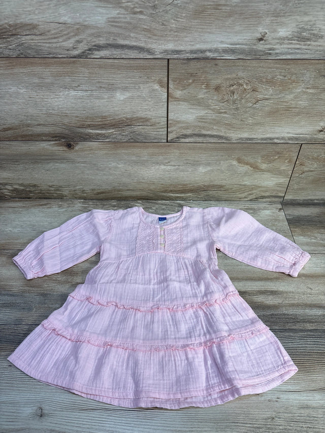 Flat lay of pink Old Navy long-sleeve tiered dress showing ruffled tiers, front buttons, textured fabric on wood background