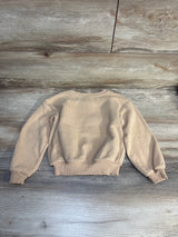 Beige kids crewneck sweatshirt with ribbed cuffs and hem on wood background