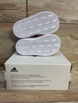 White Adidas toddler sneakers with wave-pattern soles, displayed on box, ideal for kids' footwear resale.