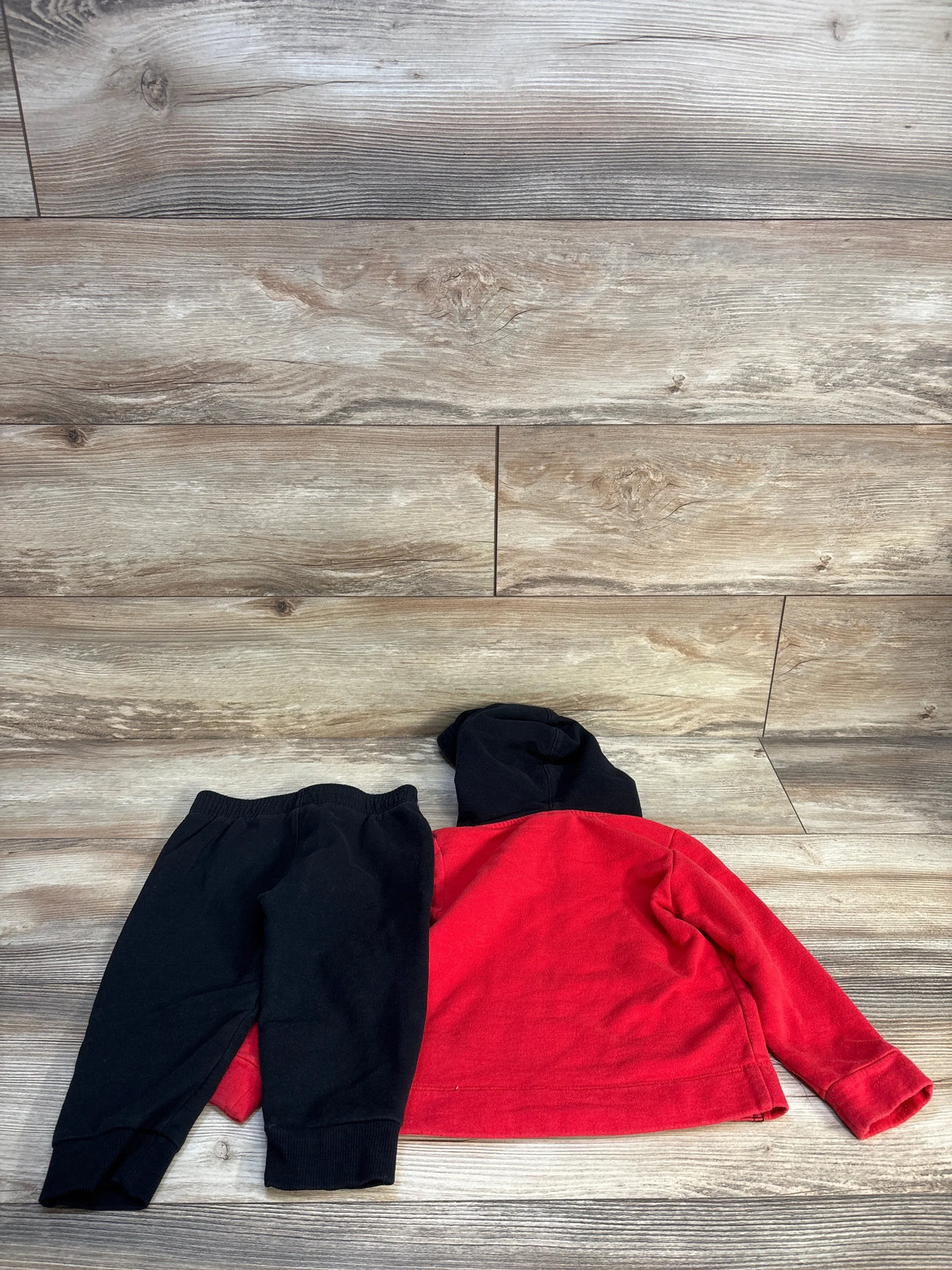 Red and black toddler hoodie with matching black pants on wood background