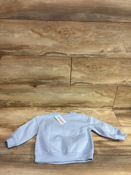 New light blue Cat & Jack toddler sweatshirt for size 18m on a wood background