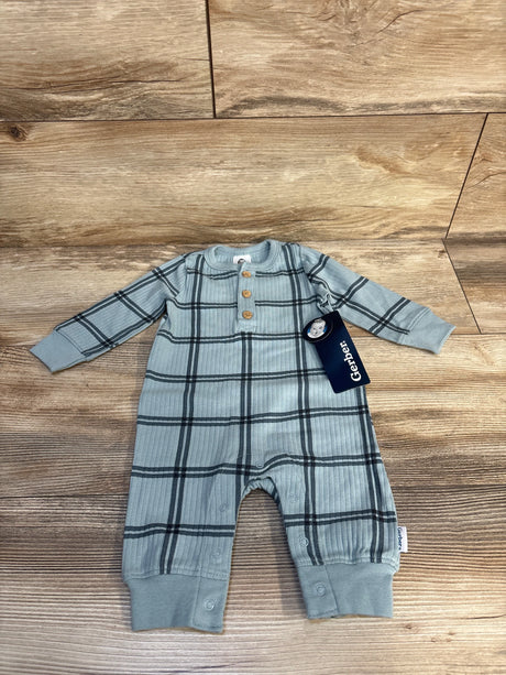 Plaid long sleeve baby romper with buttons, Gerber tag, on wood background