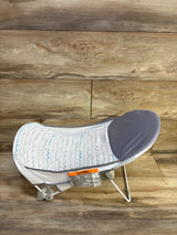 Side view of Summer Deluxe Baby Bather in grey showcasing mesh seat and padded headrest with wood floor background