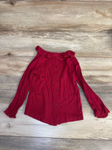 Red long sleeve toddler shirt with ruffled collar and sleeves on wood background