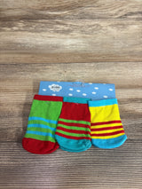 Top-down view of a 3-pack of baby socks showing bright striped patterns in green, red, teal and yellow on a blue display card on a wood tabletop