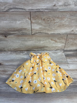 Flat lay of Baby Starters yellow tulle bodysuit dress showcasing gathered waist and floral and heart print skirt on wood background