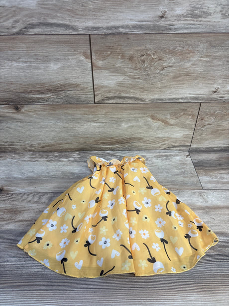 Flat lay of Baby Starters yellow tulle bodysuit dress showcasing gathered waist and floral and heart print skirt on wood background