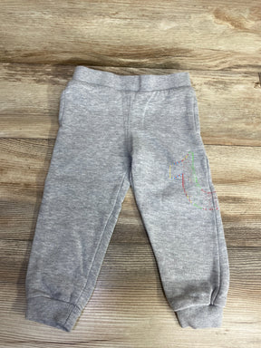 Gray toddler sweatpants with multicolored stitched number one on leg, laid on wooden floor
