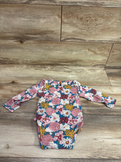 Ruffle Butts blue long sleeve floral bodysuit for babies laid on a wood floor