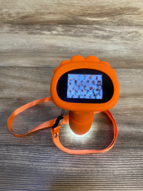 Orange kids digital microscope with display and wrist strap on wood surface