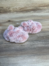 Pink fuzzy baby booties on wooden background, soft infant footwear