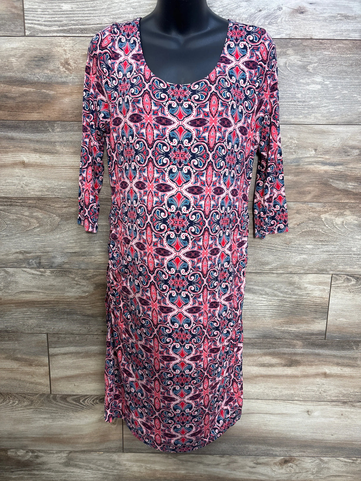 Front view of Jessica Simpson pink maternity dress XL with scoop neck, 3/4 sleeves, and navy-pink medallion print on wood backdrop