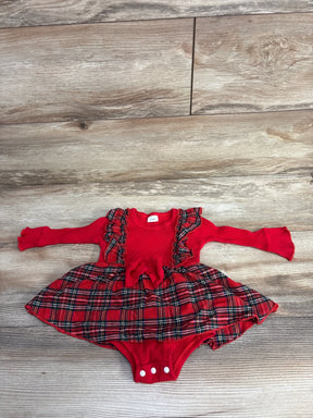 Red plaid baby dress with ruffle details and long sleeves, laid on wood floor