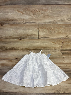 Top-down of white eyelet embroidered dress (Cat & Jack 2T) showing smocked bodice, thin straps and tiered skirt on wood floor