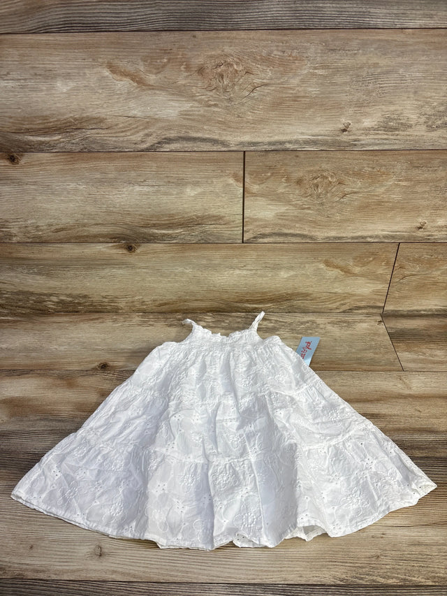 Top-down of white eyelet embroidered dress (Cat & Jack 2T) showing smocked bodice, thin straps and tiered skirt on wood floor