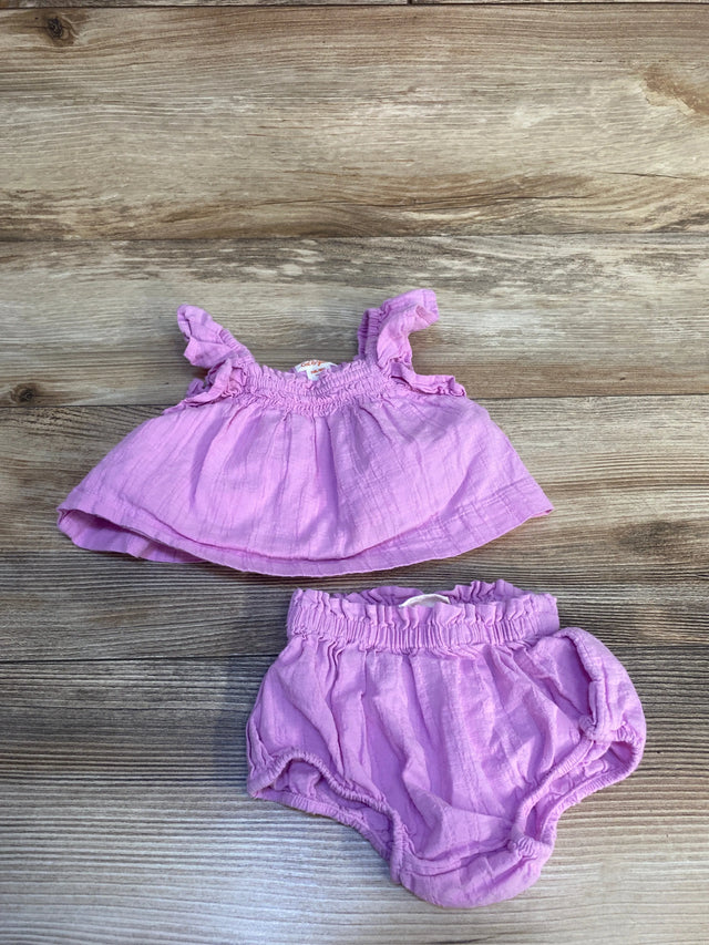 Light purple baby girl outfit with ruffle top and matching bloomers on wood background