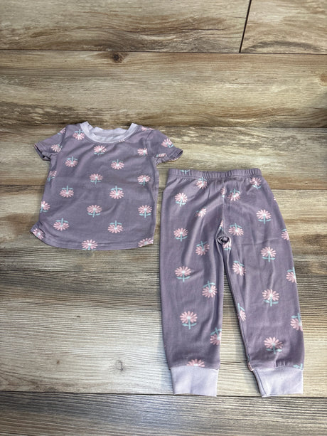 Purple floral toddler pajama set with short sleeves and elastic waist pants on wood floor