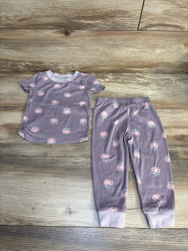 Purple floral toddler pajama set with short sleeves and elastic waist pants on wood floor