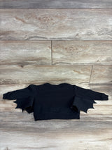 Black bat-wing kids sweater on wooden floor, perfect for Halloween or playful outfits.